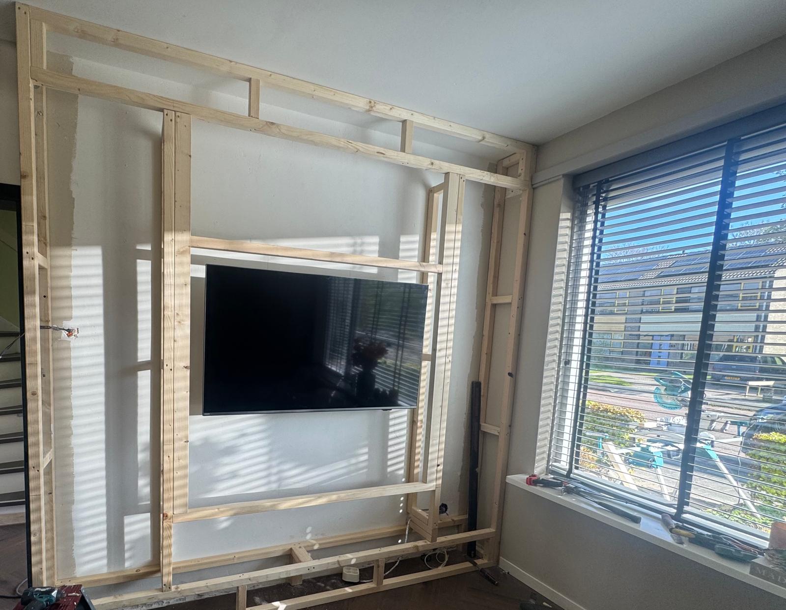Houten constructie van de cinewall met de tv geplaatst